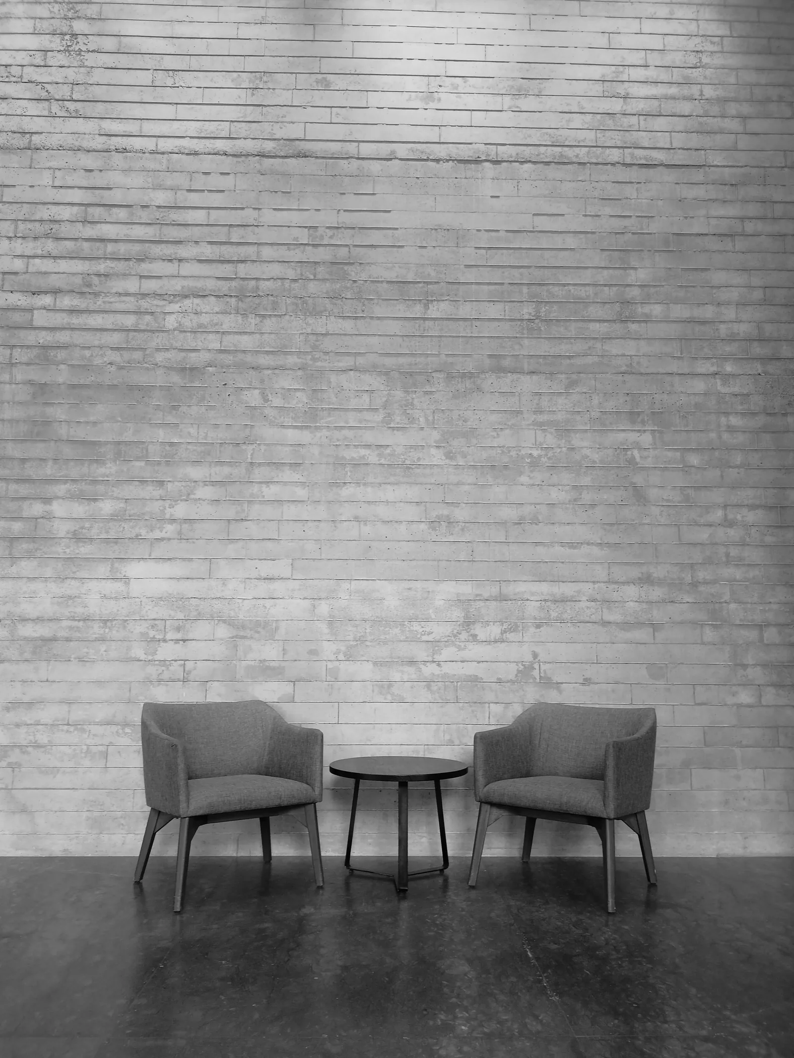 Two chairs against the concrete wall of the studio